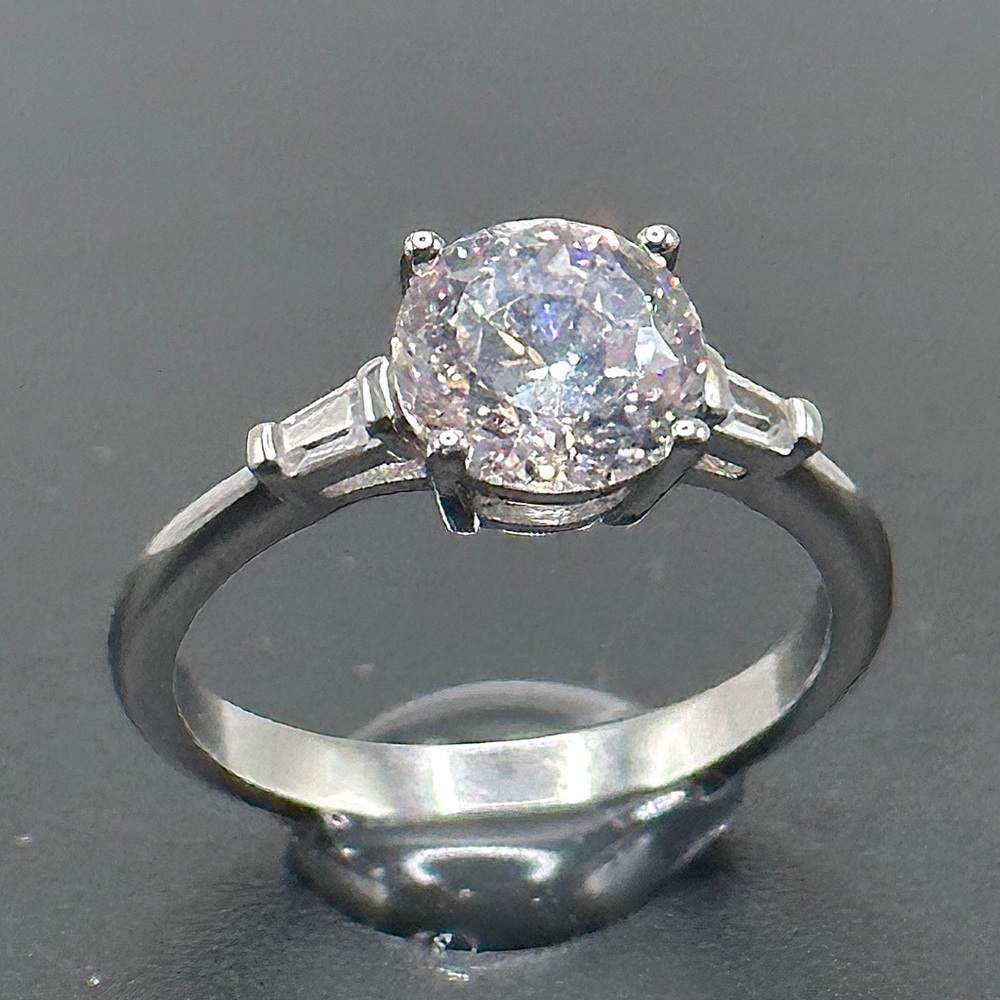 2 Carat Moissanite solitaire with .10 baguette accents.